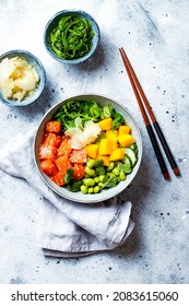 Hawaiian Salmon Poke Bowl With Seaweed, Avocado, Edamame, Mango And Pickled Ginger. Top View, Overhead, Flat Lay