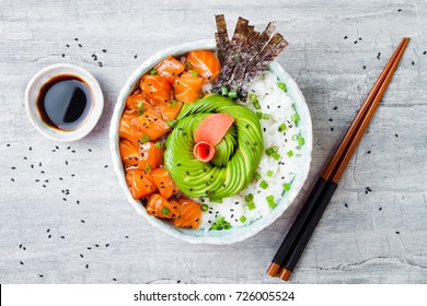 Hawaiian salmon poke bowl with seaweed, avocado rose, sesame seeds and scallions. Top view, overhead, flat lay - Shutterstock ID 726005524