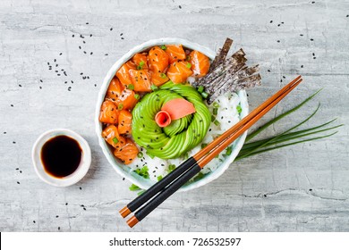 Hawaiian Salmon Poke Bowl With Seaweed, Avocado Rose, Sesame Seeds And Scallions. Top View, Overhead, Flat Lay