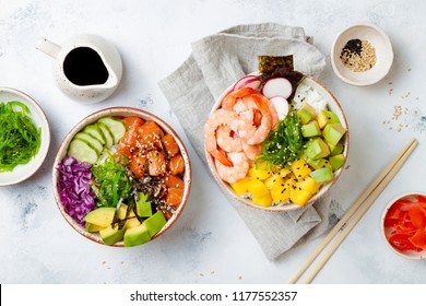 Hawaiian salmon and shrimp poke bowls with seaweed, avocado, mango, pickled ginger, sesame seeds. Top view, overhead, flat lay