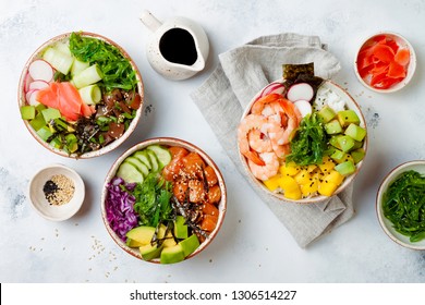 Hawaiian salmon, tuna and shrimp poke bowls with seaweed, avocado, mango, pickled ginger, sesame seeds. Top view, overhead, flat lay - Shutterstock ID 1306514227