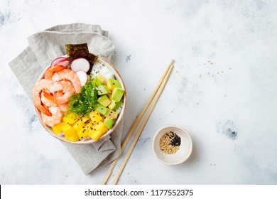 Hawaiian shrimp poke bowl with seaweed, avocado, mango, radish, sesame seeds. Top view, overhead, flat lay, copy space