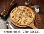 Hawaiian Tropicana Pizza isolated on cutting board top view on table italian fastfood