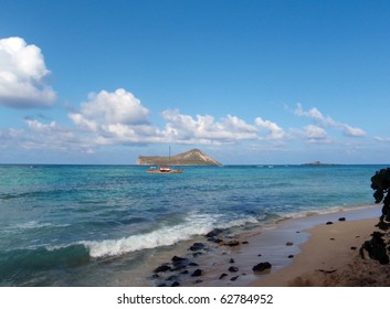 Hawaiian-style Catamaran Sails By Rabbit Island Seen From Waimanalo Beach Oahu, Hawaii.