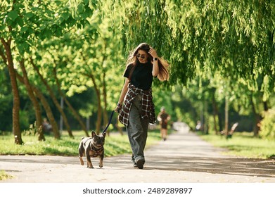 Hawing a walk. Young pretty woman is with her dog in the park. - Powered by Shutterstock