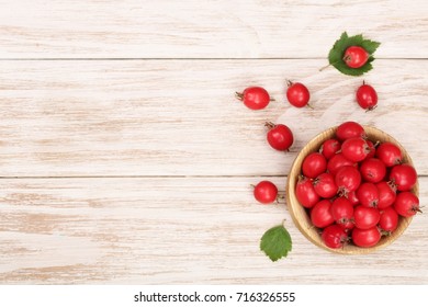 Hawthorn Berry With Leaves In Bowl On White Wooden Background With Copy Space For Your Text. Top View