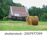 Hay bale with abandoned weathered barn stable farm homestead pasture