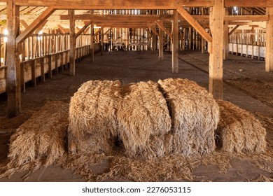 Hay bales stacked in old wooden barn on historic cattle ranch