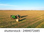 Hay making in field. Tractor with round baler. Making Hay Bales in agricultural field. Round Hay Bale Tractor Baler. Balers to roll. High-quality square bales. Baler making Hay Bales in Farm field.