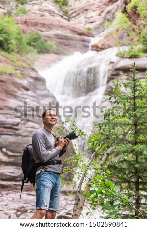 Hays creek falls in Redstone, Colorado during summer with man photographer standing with camera happy smiling