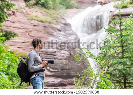 Hays creek falls waterfall in Redstone, Colorado during summer with man photographer standing with camera looking at view
