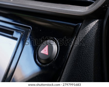 Hazard light button close up on car dashboard console panel, automotive emergency flasher switch in vehicle interior
