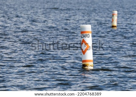 Hazard safety buoys alerting boaters to navigation danger. Nautical warning caution floats.