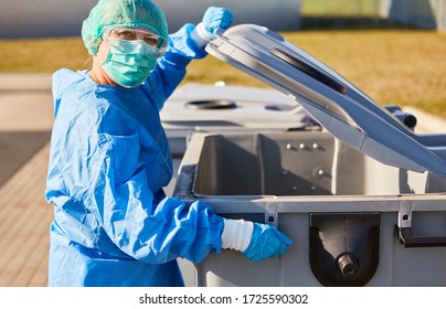 Hazardous waste Waste disposal in garbage can from clinic with protective clothing due to coronavirus pandemic