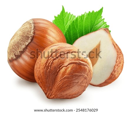 Hazelnuts, split of hazelnut kernel and green leaves on white background. Clipping path.