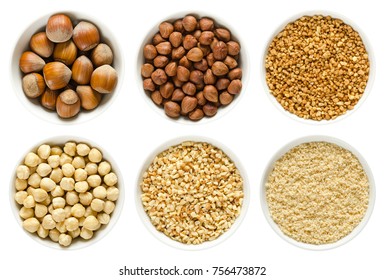 Hazelnuts In White Bowls. Whole Nuts, Shelled, Blanched And Roughly Chopped. Ground Hazelnuts And Hazelnut Brittle. Corylus Avellana. Macro Photo, Close Up, From Above, Isolated, On White Background.