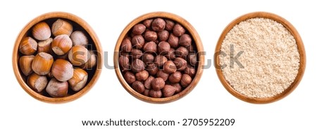 Hazelnuts, with and without shells, and ground, in wooden bowls. Dried hazelnuts, seeds of the hazel tree Corylus avellana in the left bowl, shelled nuts in the center, and ground in the right bowl.