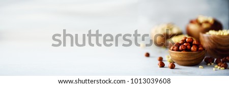 Hazelnuts in wooden bowl. Food mix background, top view, copy space, banner. Assortment of nuts - cashew, hazelnuts, walnuts, pistachio, pecans, pine nuts, peanut, raisins