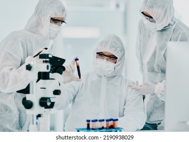 Hazmat Suit Scientists With Test Tube In Medical Research, Healthcare Or Science Cure Testing For Covid, Marburg Virus Or Ebola. Group Of Laboratory Professionals Looking Or Checking DNA Blood