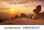 A hazy gravel desert with bizarrely shaped rocks at sunset in Agadir- Morocco.