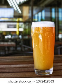 Hazy IPA Beer On A Restaurant Patio. On A Wooden Table.