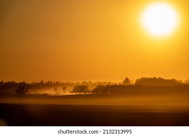 A hazy landscape field during sunset