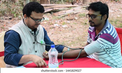 HBPYS, Sindrani, Harinagar, WB, India On 16th Dec 2018: Doctor Checking Blood Donor At A Blood Donation Camp Organised By HBPYS In A Village Outdoor.