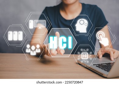 HCI concept, Human computer interaction, Person hand using computer on office desk with HCI icon on virtual screen.