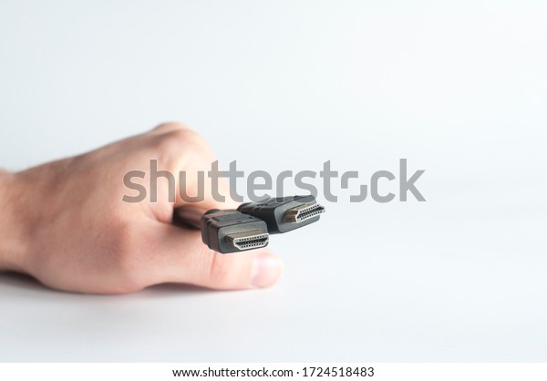 HDMI\
cable. USB plug. In hand on a white\
background