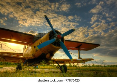HDR foto of an old airplane on green grass and sunset background