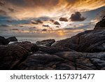 HDR processed dramatic sunset over sea beach on south islands in Thailand with a natural rock in the foreground.