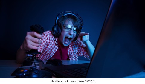 He had revenge in video games. In blue light of monitor emotional kid play computer games online. - Shutterstock ID 266730110
