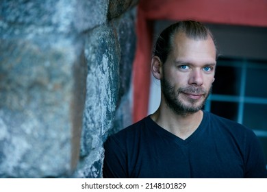 He Has A Quiet Confidence About Him. Portrait Of A Man Leaning Against A Wall Outside.