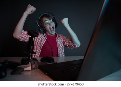 He like play and win video games. In blue light of display emotional kid play computer games online. - Shutterstock ID 277673450