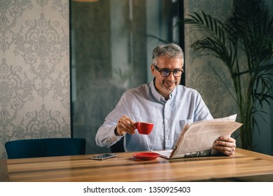 he likes to have coffee break in his favorite cafe bar. man reading newspaper. - Powered by Shutterstock