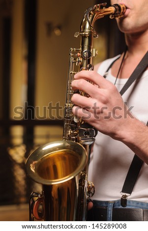 He likes to improvise on his saxophone. Close-up shot of men holding a saxophone