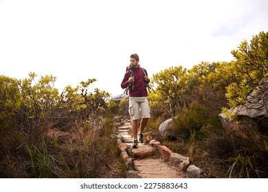 He loves a good hike. a young man enjoying a hike through the mountains.