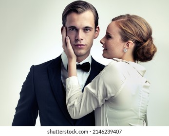 He makes them weak at the knees. A cropped studio portrait of a dapper young man with a beautiful girl on his arm.