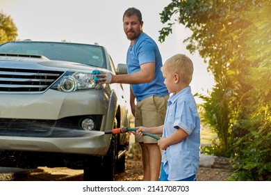 He may be young but hes still very helpful. Cropped shot of a father and son washing a car together. - Powered by Shutterstock