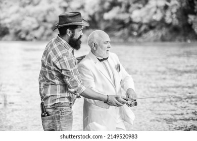 he need help. hobby and recreation. two fishermen with fishing reel. family, granddad and drandson fishing. retired businessman. male friendship. mature man fisher celebrate retirement