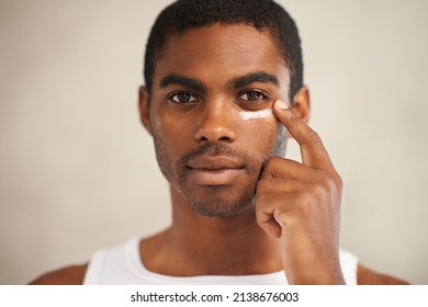 He takes care of his skin. A young man applying face cream. - Powered by Shutterstock