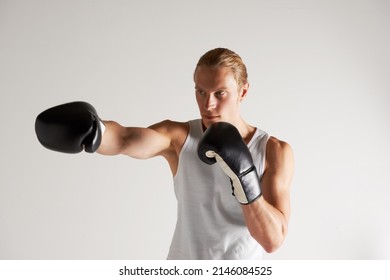 He takes his boxing career very seriously. A handsome young male boxer wearing a vest and throwing a punch. - Powered by Shutterstock