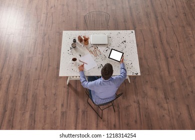 He is working at office and using tablet style.
