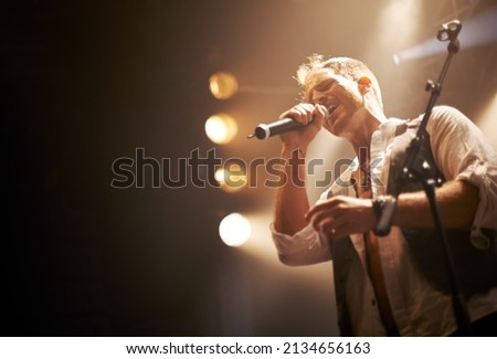 He wrote this one himself. Cropped shot of a performer on stage.