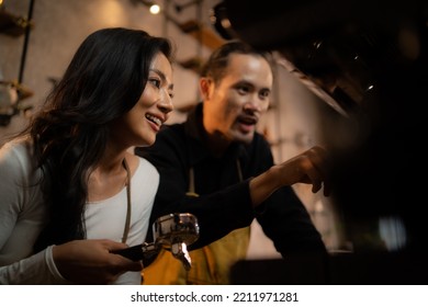 The Head Barista Is Training A Female Employee In Front Of A Coffee Machine.