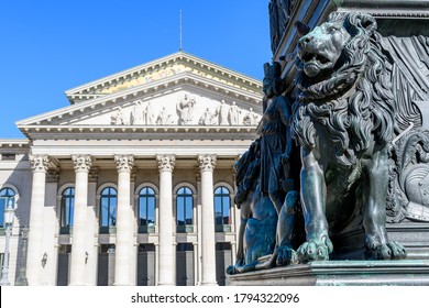 Head of the Bavarian lion at the Max Joseph monument in Munich, heraldic animal and symbol of Bavaria for power strength prudence and justice. In the background the Opera