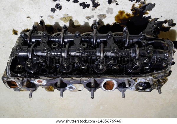 The head of the block of\
cylinders. The head of the block of cylinders removed from the\
engine for repair. Parts in engine oil. Car engine repair in the\
service.