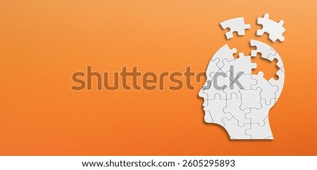Head and brain diseases concept. A missing pieces of the brain puzzle on orange background.