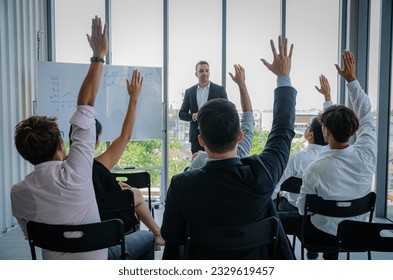 Head of Business Training Sales and Marketing Teams.Male employee raising his hand to ask boss.Many people sat and listened to seminar. - Powered by Shutterstock