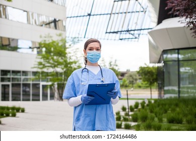 Head Of Care Wearing Personal Protective Equipment Holding Folder Standing In Front Of Nursing Home,Coronavirus COVID-19 Pandemic Outbreak Crisis,worried Exhausted Frontline Staff,medical Key Worker